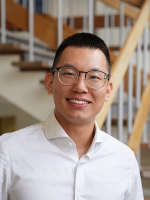 A portrait of Tong Lu wearing a white shirt