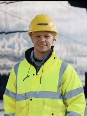 A portrait of John Casey wearing bright yellow high-vis