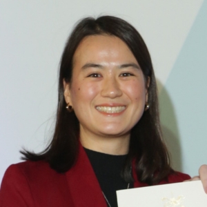A headshot photo of Jane Wright smiling and wearing a red jacket.
