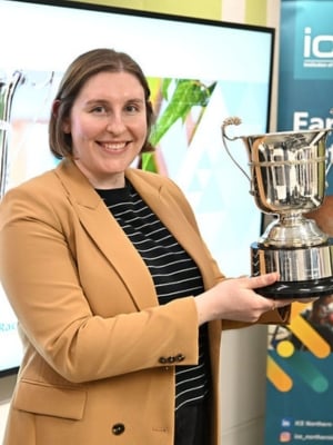 A portrait of Rachel Woodward holding the Brennan cup