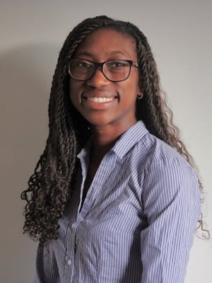 A portrait of Esther Fobi wearing a blue striped shirt