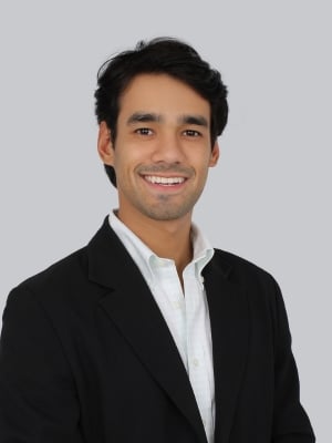 A portrait of Jesús David De Oliveira against a grey background