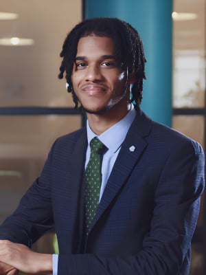 A portrait of Aamar Lovell wearing a navy suit