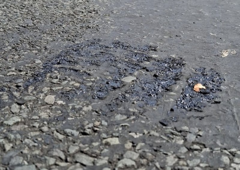 Close-up of a road surface showing asphalt binder bleeding and softening in hot weather. Image credit: Ken Evans
